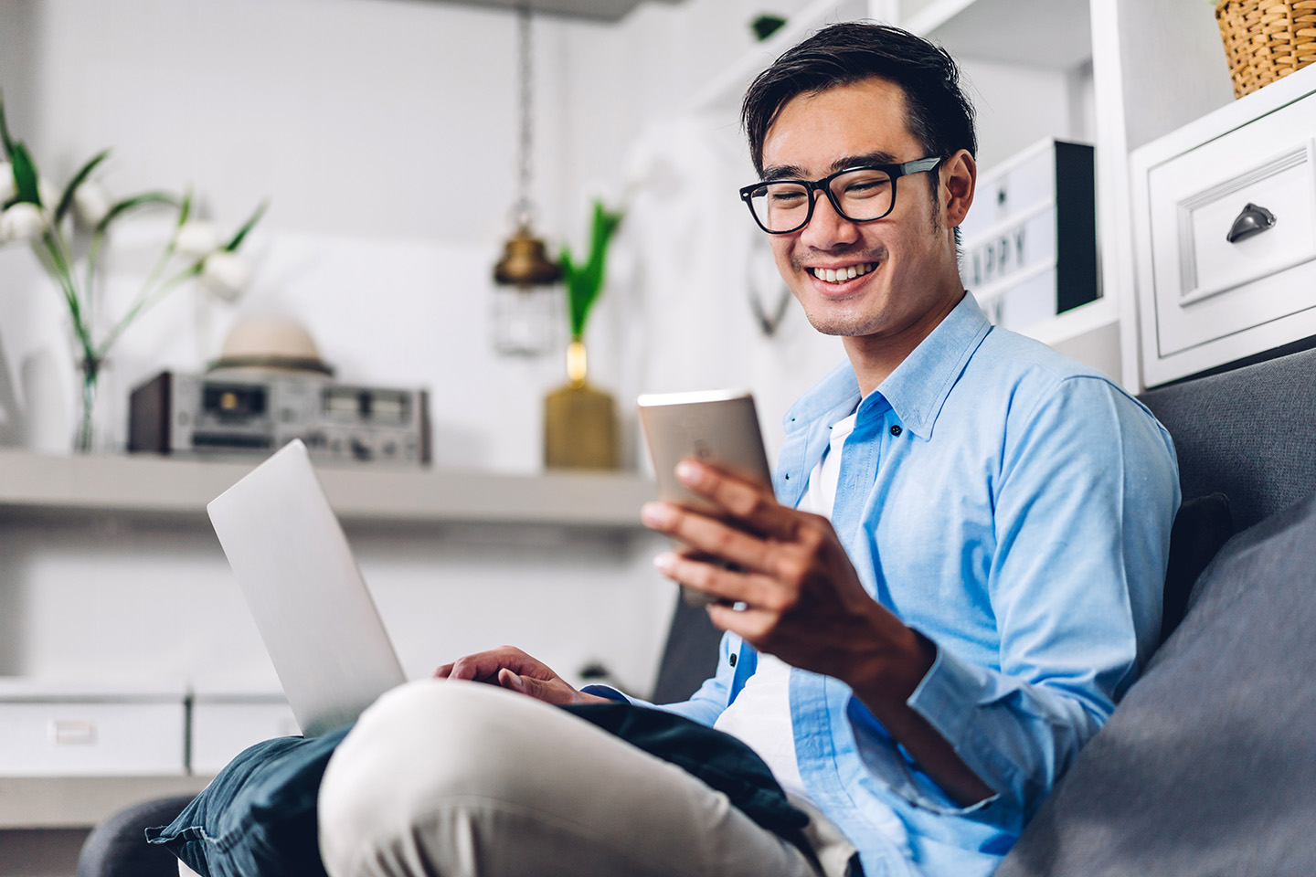 young-smiling-asian-man-relaxing-laptop-computer-smartphone-video-meeting View, save and grow your finances with budgeting apps