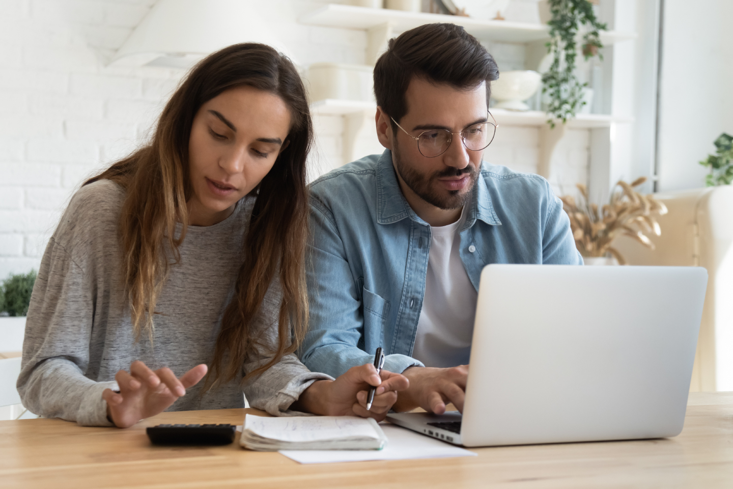 serious-man-woman-bills-calculator-laptop