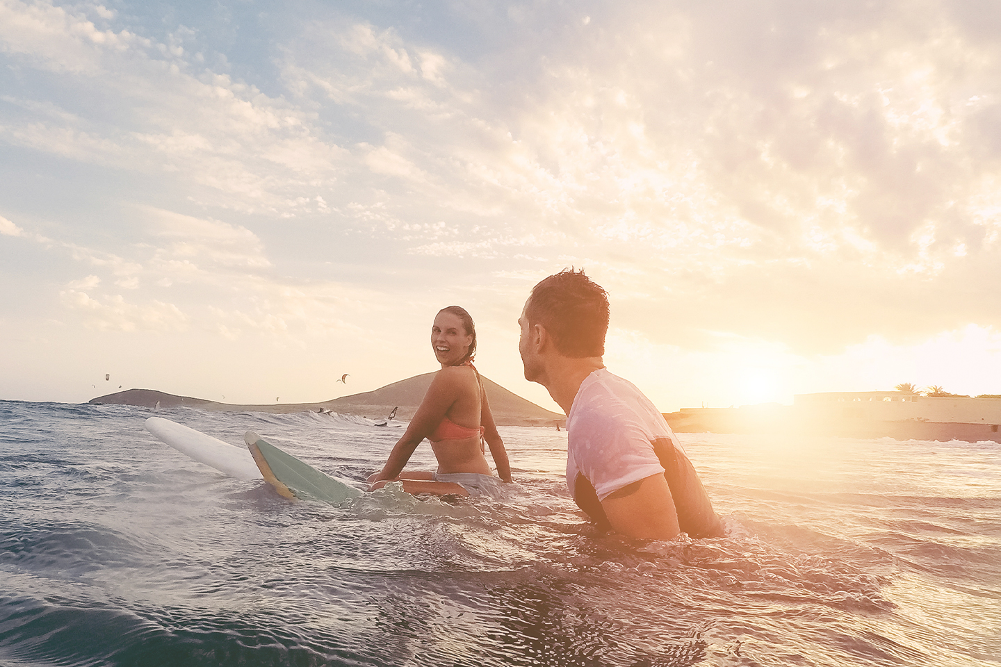 fit-couple-surfing-sunset