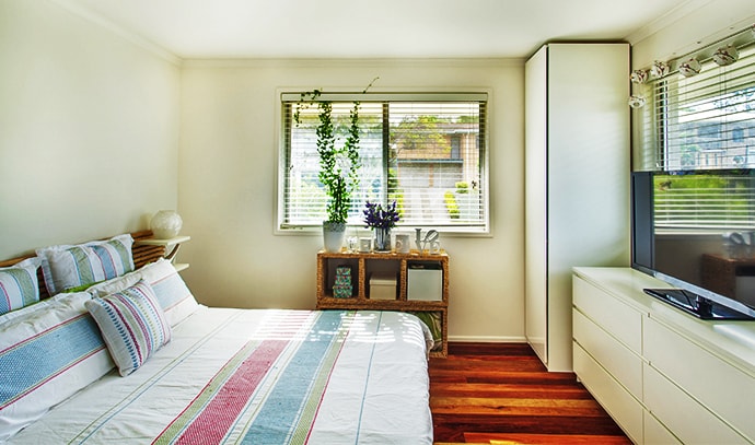 vibrant-bedroom-near-windows-flat-screen