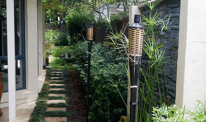 side-passage-plants-brick-wall-tiki-torch