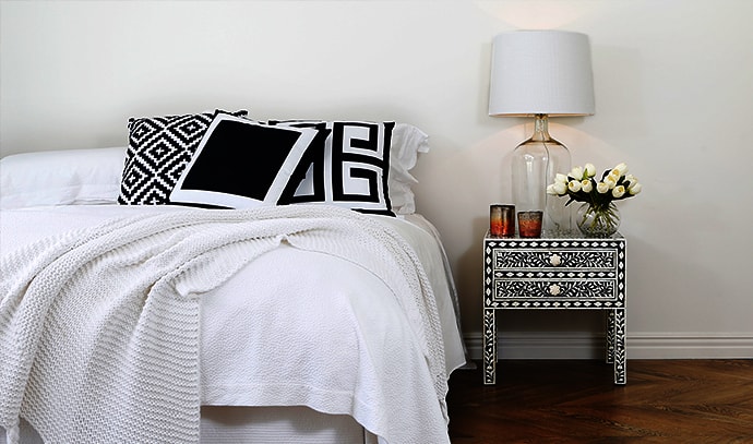 zohi-interiors-bedroom-white-covers-black-pillows-white-lamp-black-bedside-table
