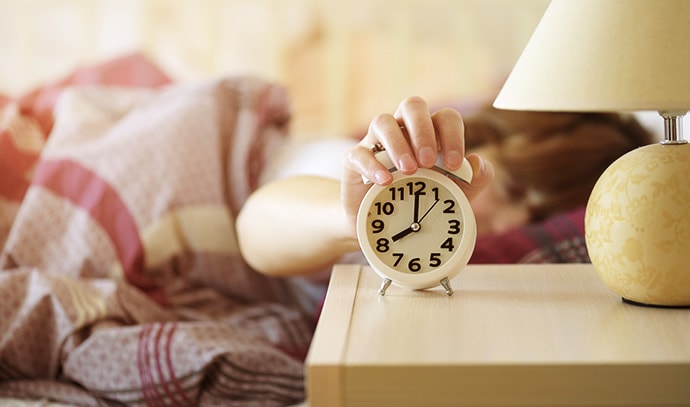 woman-waking-up-turning-off-the-alarm-clock