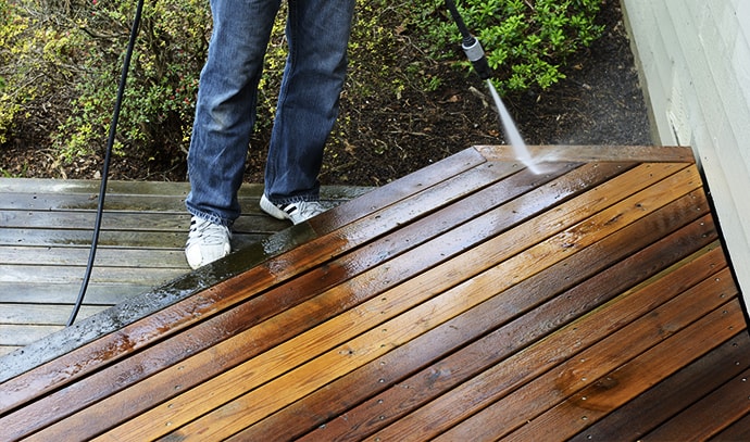 man-cleaning-deck-using-pressure-washer