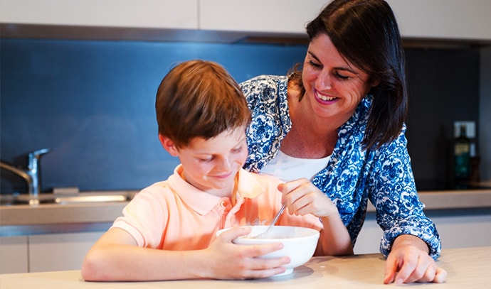 mom-watching-her-son-eat-breakfast-at-kitchen