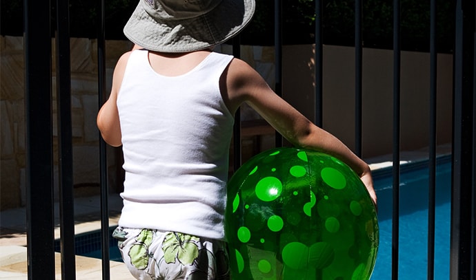 child-in-front-of-gate-of-swimming-pool