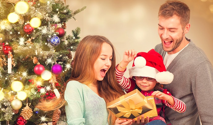 family-mom-dad-helping-daughter-open-gift-presents-christmas-tree