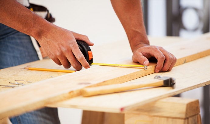 builder-engineer-uses-tape-measure-construction