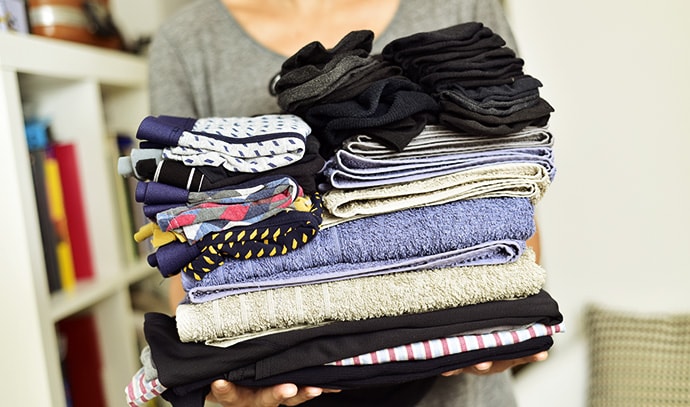 young-man-pile-folded-clothes