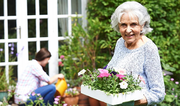 teenage-granddaughter-helping-grandmother-in-garden-planting