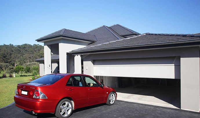 red-sedan-car-entering-garage-opening-garage-door