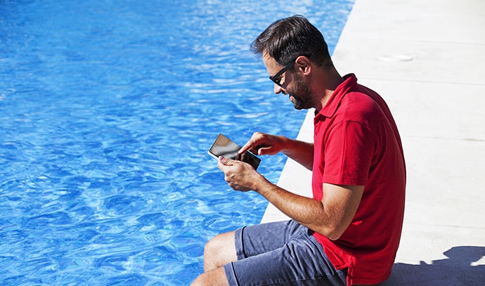 man-using-tablet-swimming-pool-home-automation