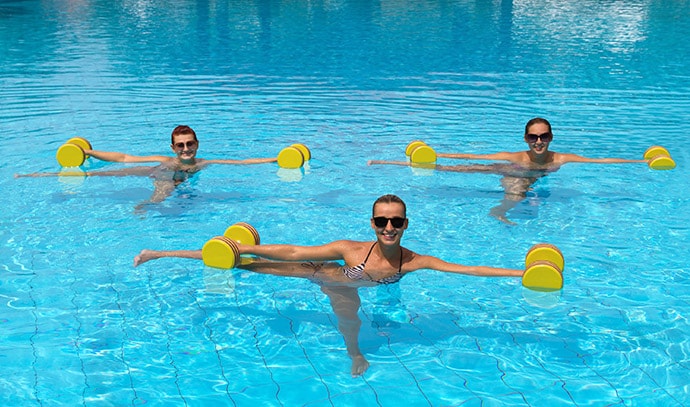 happy-active-fitness-people-doing-exercise-with-aqua-dumbbells-in-swimming-pool