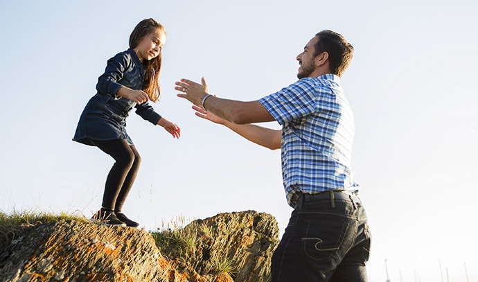 father-catches-leaping-daughter-cliff-sunset-setting