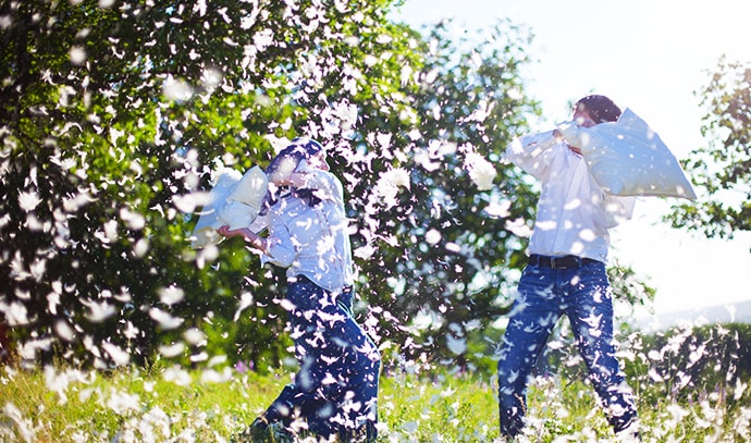 two-persons-pillow-fight-outside-raining-feathers