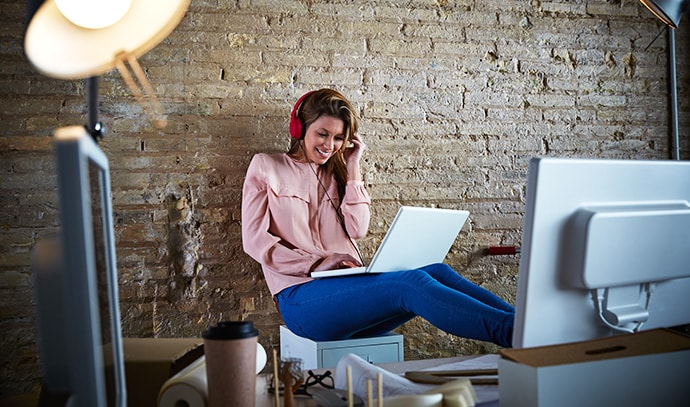 woman-hearing-music-headphones-office-laptop-relaxed-sitting