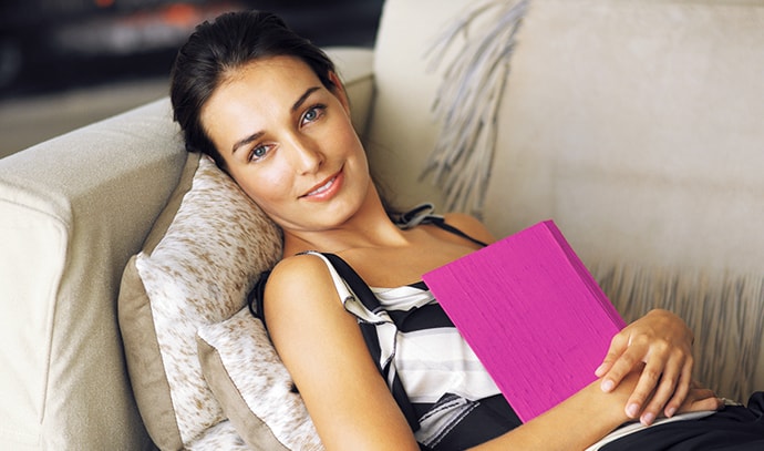 woman-resting-lying-loveseat-reading-relaxing