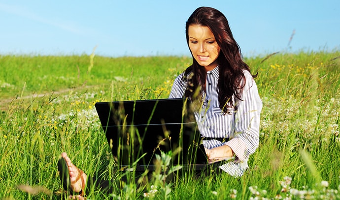 woman-green-plain-fields-work-outdoor-laptop