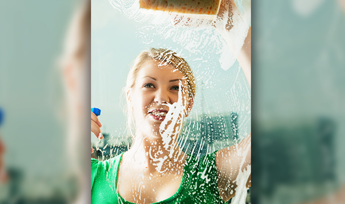 young-woman-cleaning-windows-spray-sponge