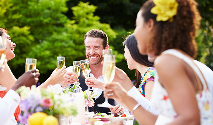 group-friends-enjoying-outdoor-dinner-party-raise-glass
