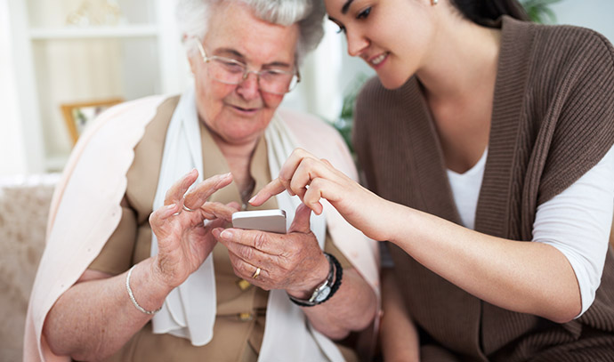 woman-teaching-grandmother-use-smartphone