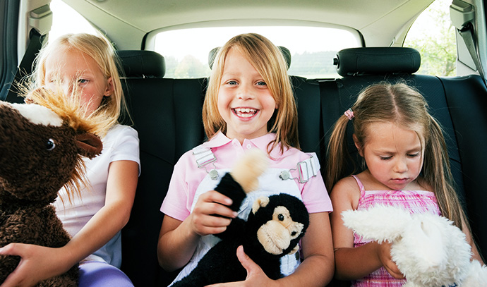 family-three-kids-stuffed-toys-car-drive