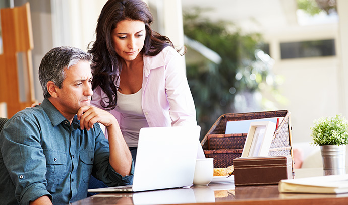 worried-hispanic-couple-laptop-desk-home