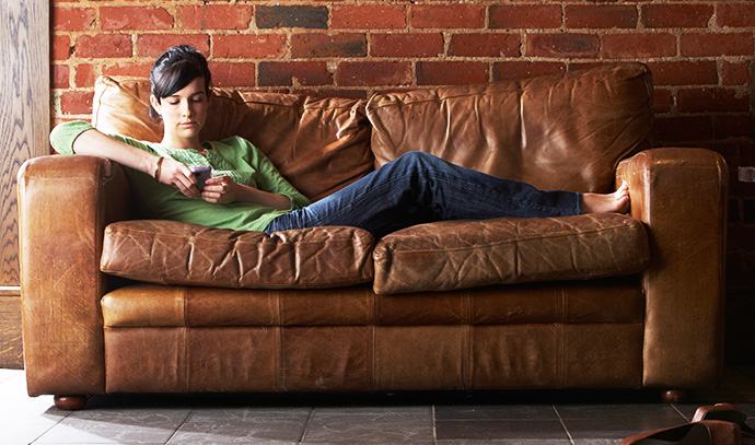 young-woman-phone-sofa-social-media-internet-relaxing