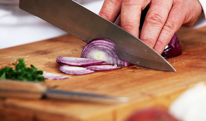 chef-slicing-red-onions-sharp-knife-chopping-board