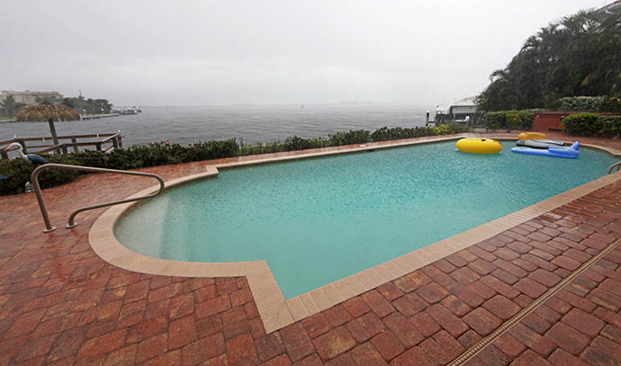 swimming-pool-overlooking-water-raining-dark-sky