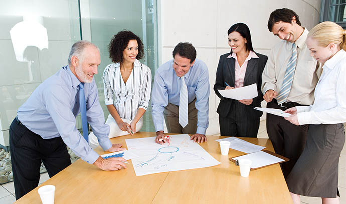 office-workers-standing-around-meeting-table