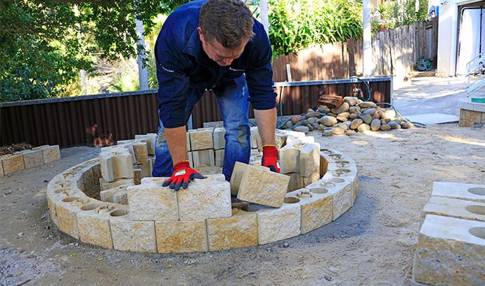 adbrimasonry-man-layering-second-course-blocks-fire-pit