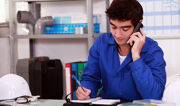 construction-worker-arranging-appointment-writing-notebook-talking-phone