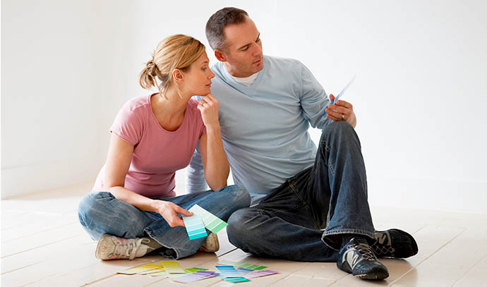 couple-sitting-floor-looking-paint-swatches