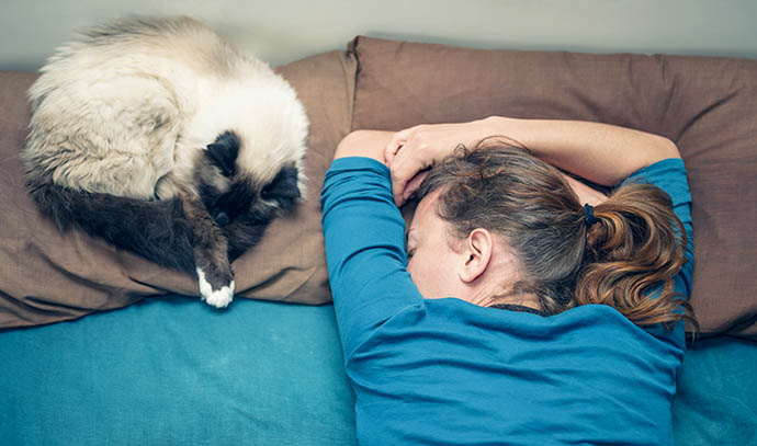 young-woman-sleeping-bed-pet-cat-next-her